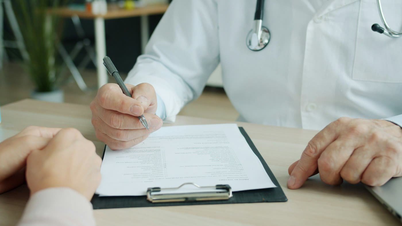 Doctor writing a prescription during a consultation
